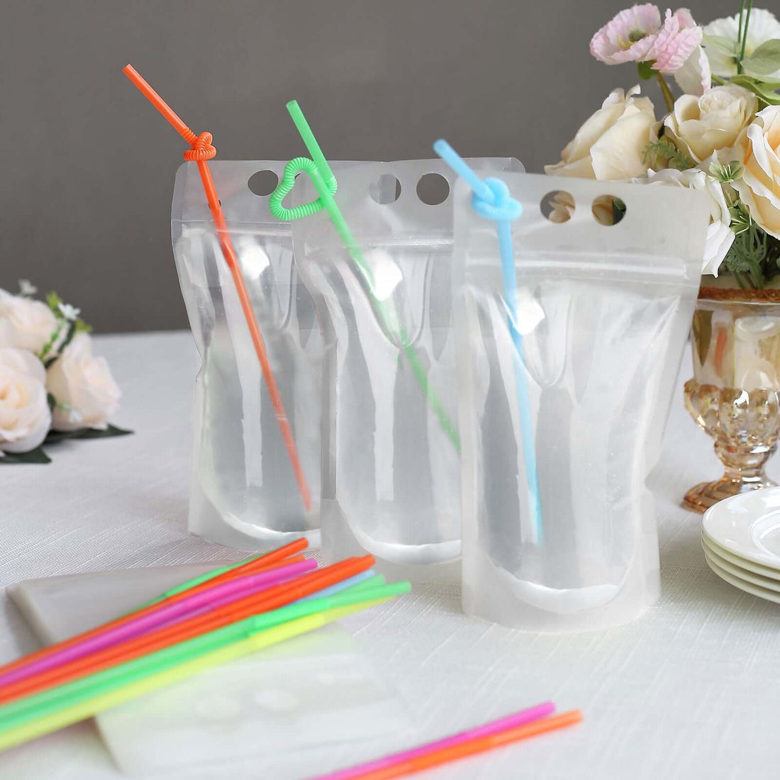 Clear reusable drink pouches with colorful straws in a stylish setting.