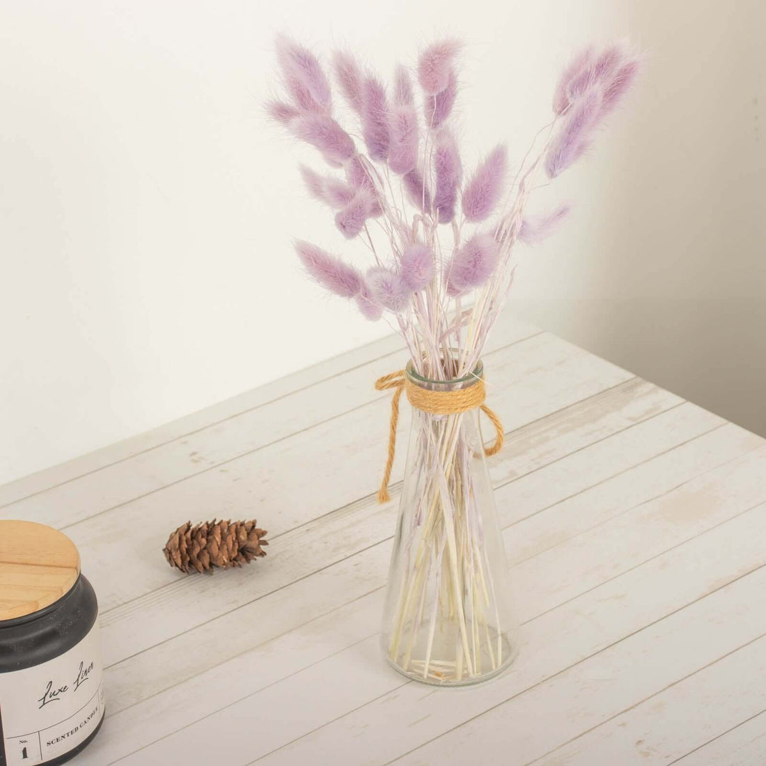 Purple dried flower bouquet in a glass vase with twine.