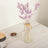 Purple dried flower bouquet in a glass vase with twine.