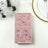 Floral-patterned pink gift box on a table with white roses and dinnerware.