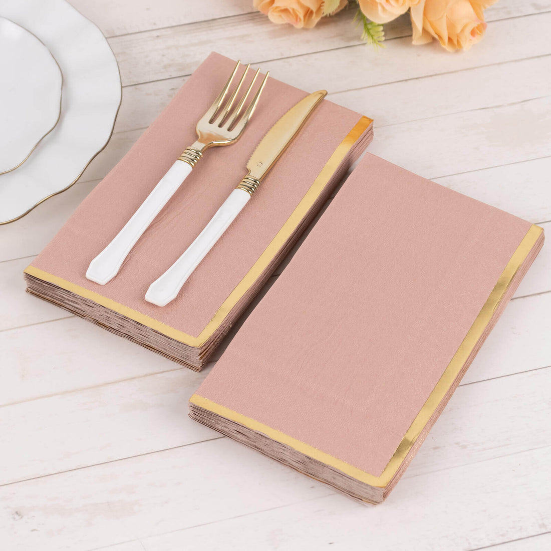 Pink napkins with gold trim, styled with a fork and knife.