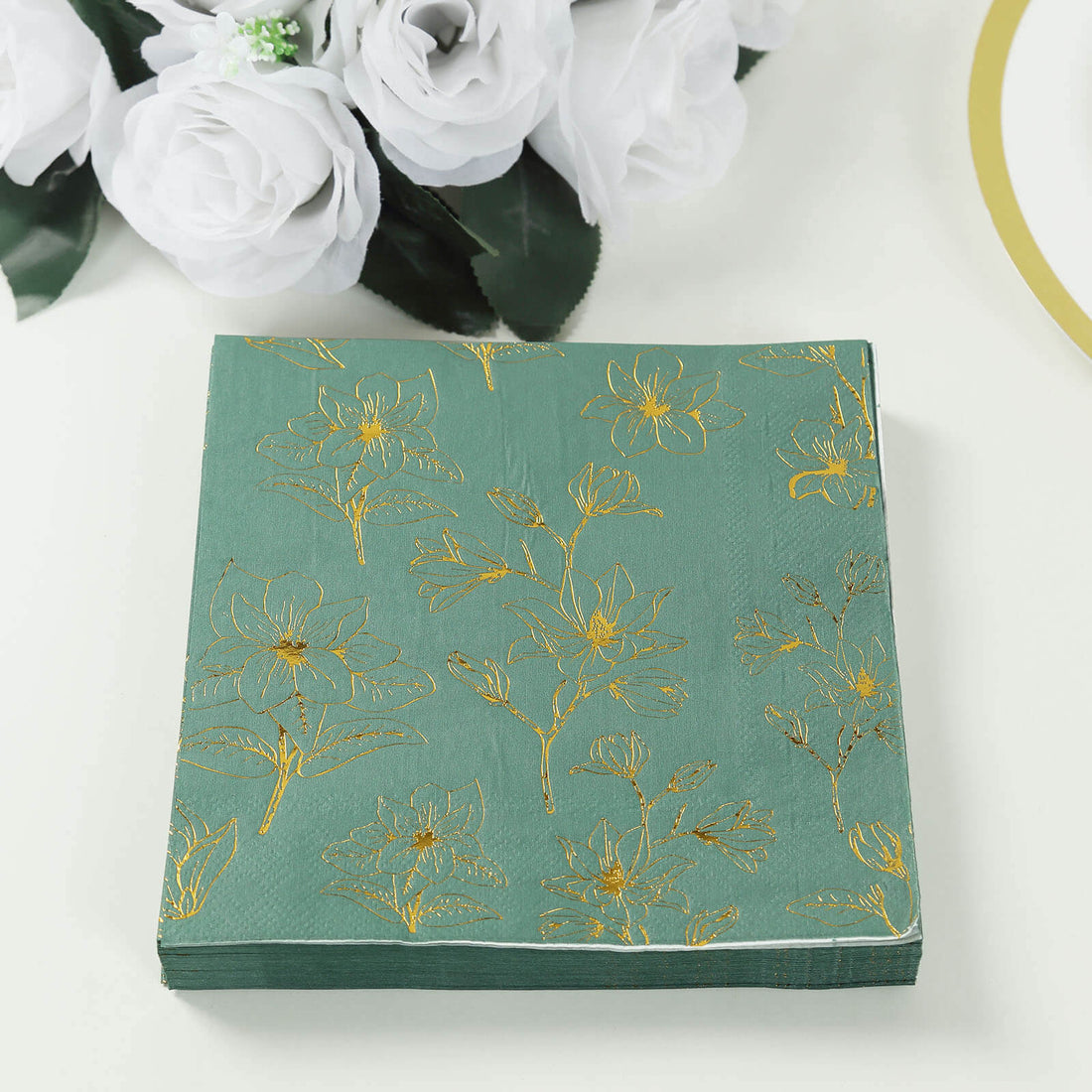 Decorative floral napkins in green with gold accents.