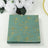 Decorative floral napkins in green with gold accents.