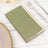 Green napkin with gold trim on a table setting.