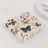Colorful butterfly-printed napkins stacked on a table.