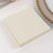 Beige sticky notes stacked on a plain surface