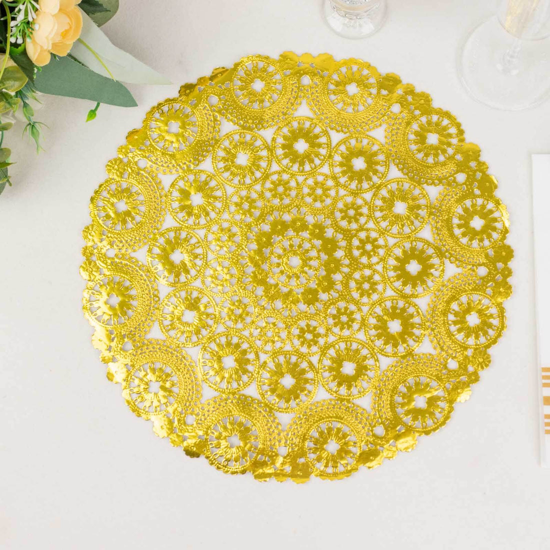 Gold decorative lace doily on a white surface.