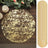 Gold textured round placemat and matching runner on a rustic wooden table.