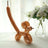 Balloon animal sculpture in gold color, styled as a cat with a long tail.