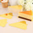 Golden cake slice with a smooth layer and decorative cutouts on a plain background.