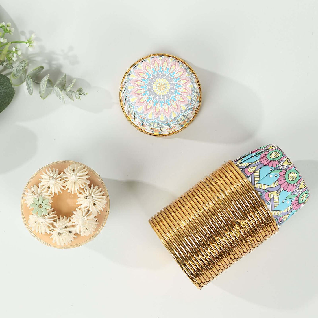 Decorative storage boxes with intricate designs on a neutral surface.