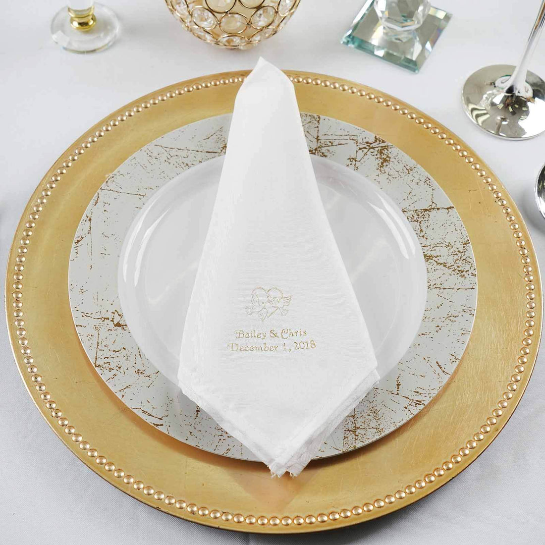 Elegant personalized wedding napkin on a decorative plate setting.
