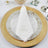 Elegant personalized wedding napkin on a decorative plate setting.