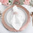 Elegant table setting with pink charger plate, white napkin, and floral decor.