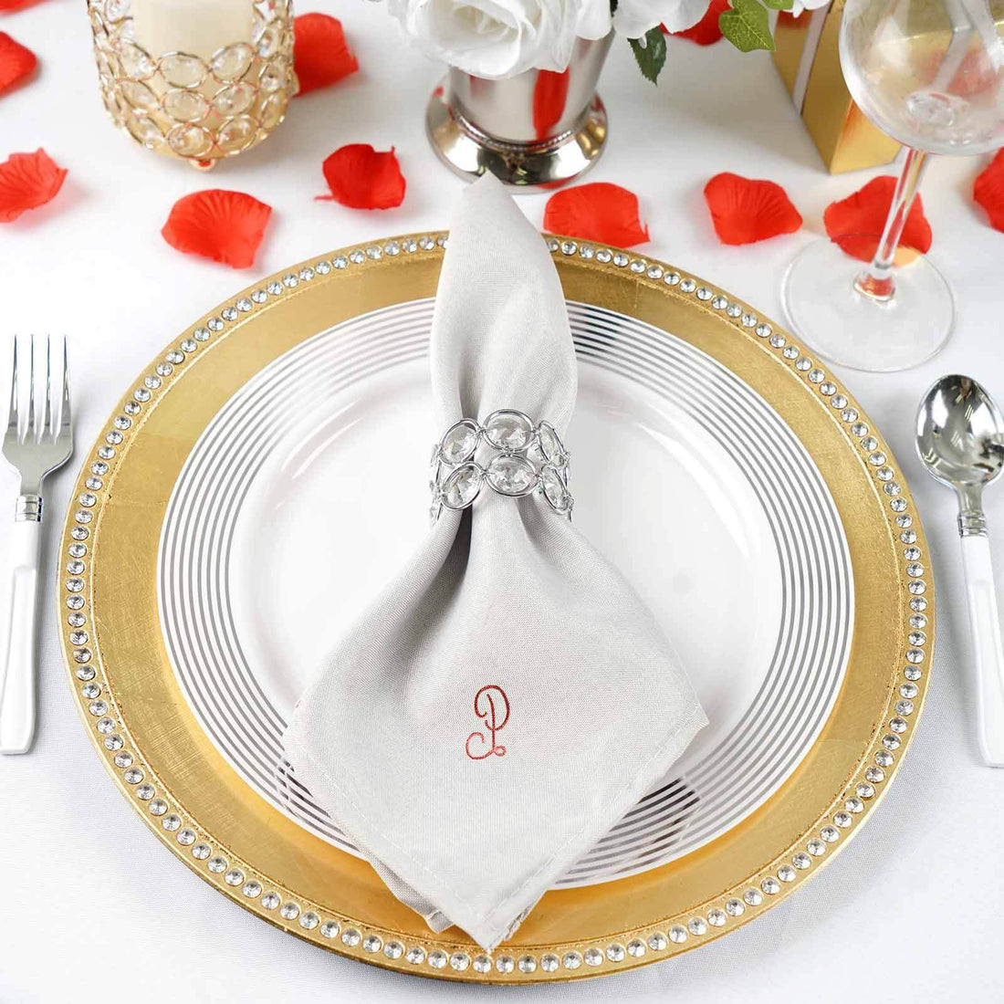 Elegant table setting with silver napkin ring and decorative plate.