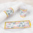 Floral-themed tableware wraps for napkins and cups on a white plate.