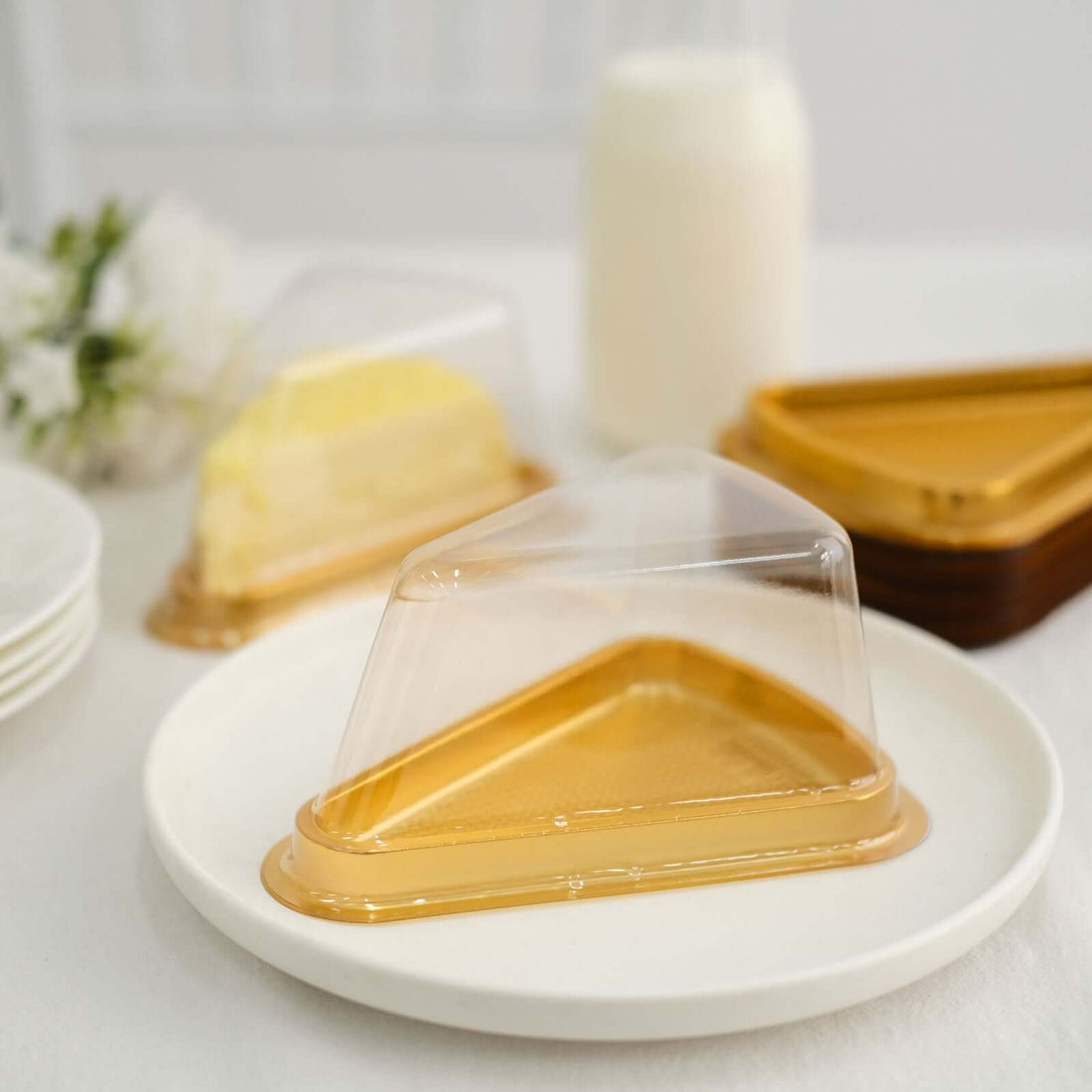 Plastic cake slice containers on a white plate with slices of cake.