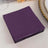 Purple paper napkins stacked on a table.