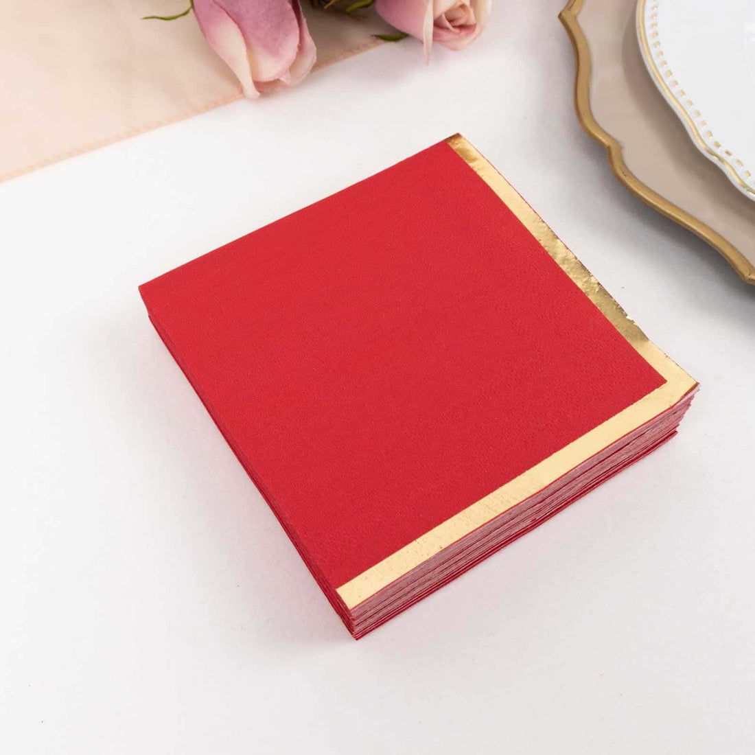 Red napkins with gold foil edges on a white background