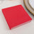 Red paper napkins stacked on a table setting.