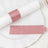 Pink glitter napkin rings and place cards on a white plate.