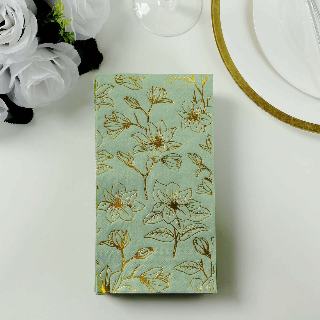 Floral patterned napkin on a table setting with white roses.
