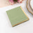 Green napkin with gold trim on a white background