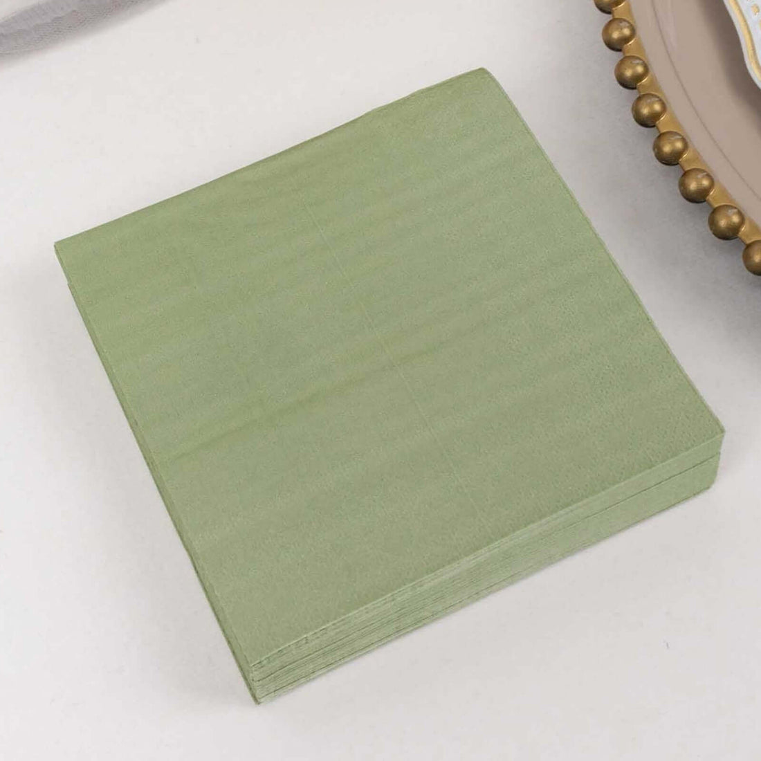Green paper napkins stacked neatly on a plain surface.