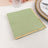 Green napkin with gold trim on a table setting.
