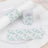 Floral-patterned napkin holder and place card on a white plate.