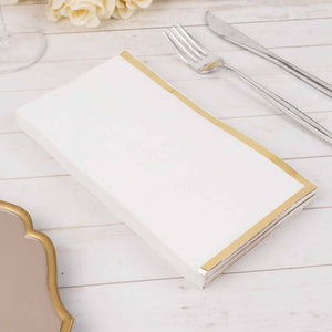 White menu with gold trim on a wooden table setting.