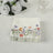 Floral paper napkins stacked on a table with decorative flowers.