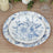 Floral design paper plates stacked on a wooden table.