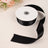 Black satin ribbon on a roll with a loose end