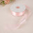 Pink satin ribbon roll with loose end displayed.
