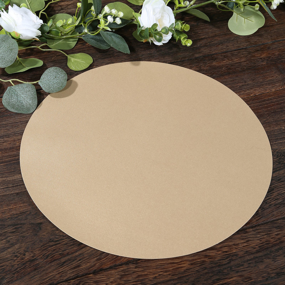 Brown circular paper on a wooden surface with greenery around it.