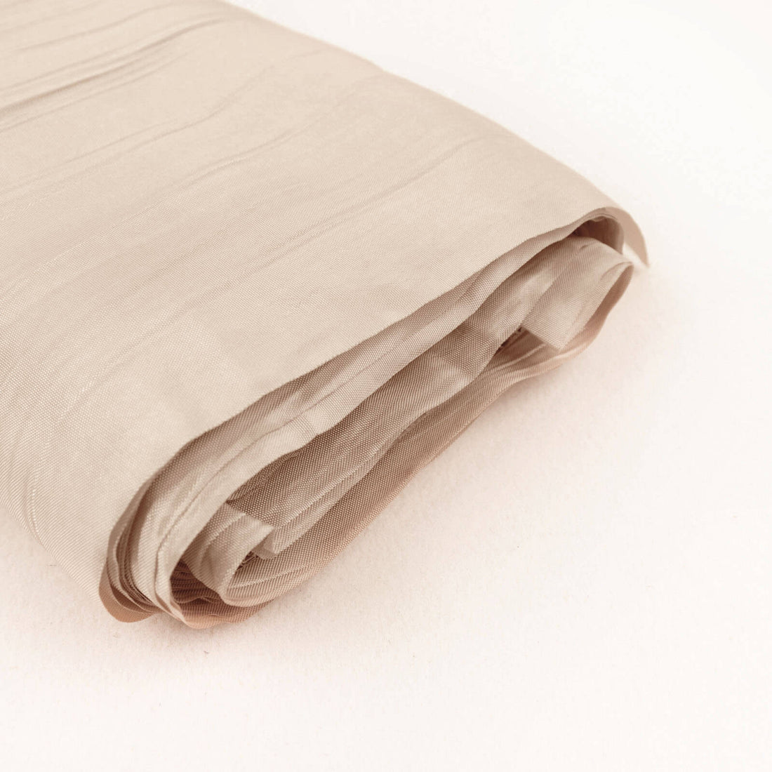 Beige fabric roll on a plain background.