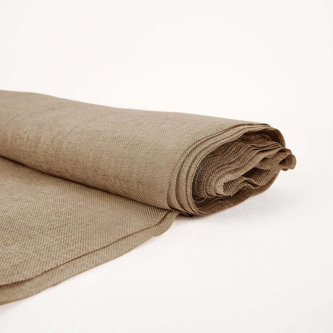 Rolled beige fabric on a white background