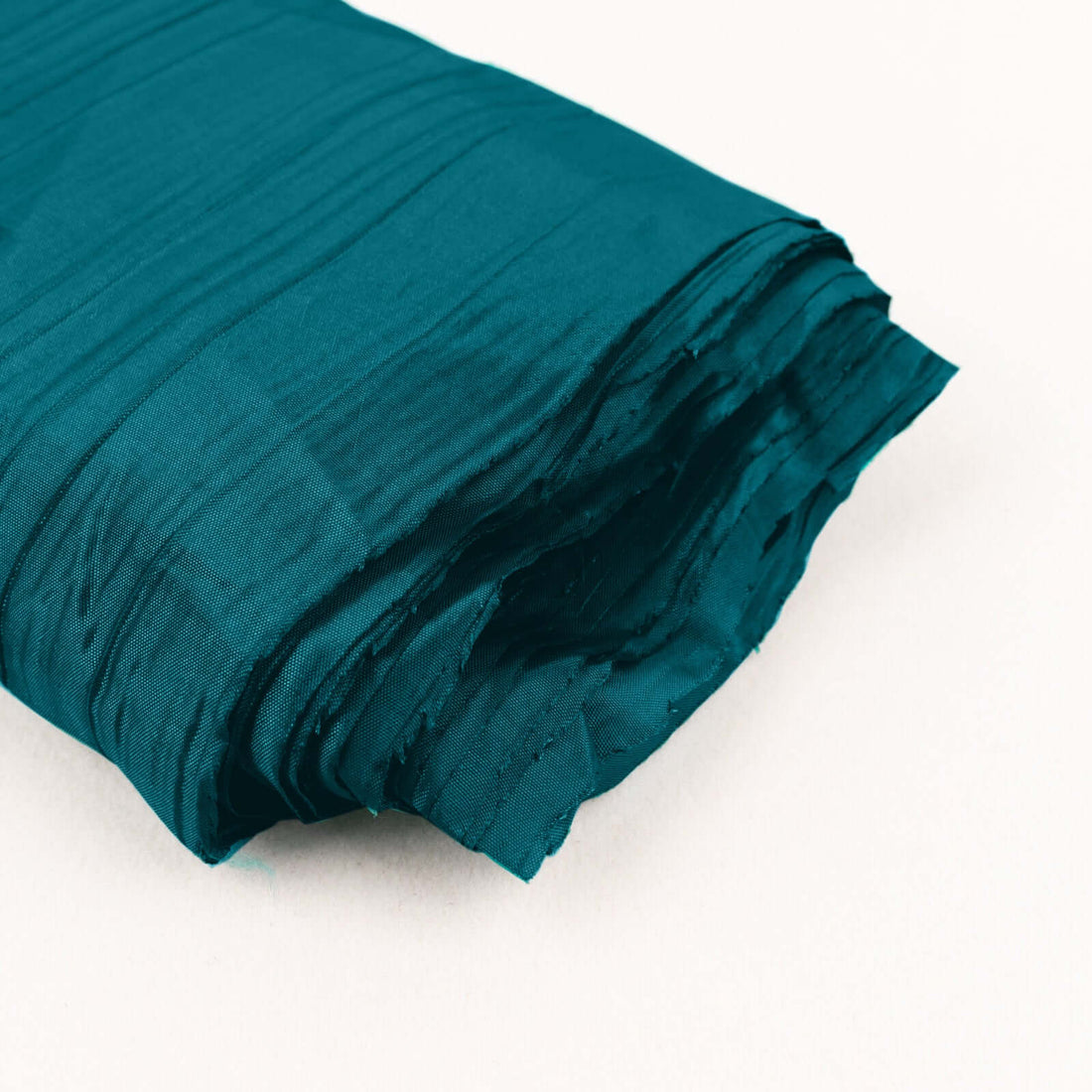 Teal crinkled fabric roll on white background