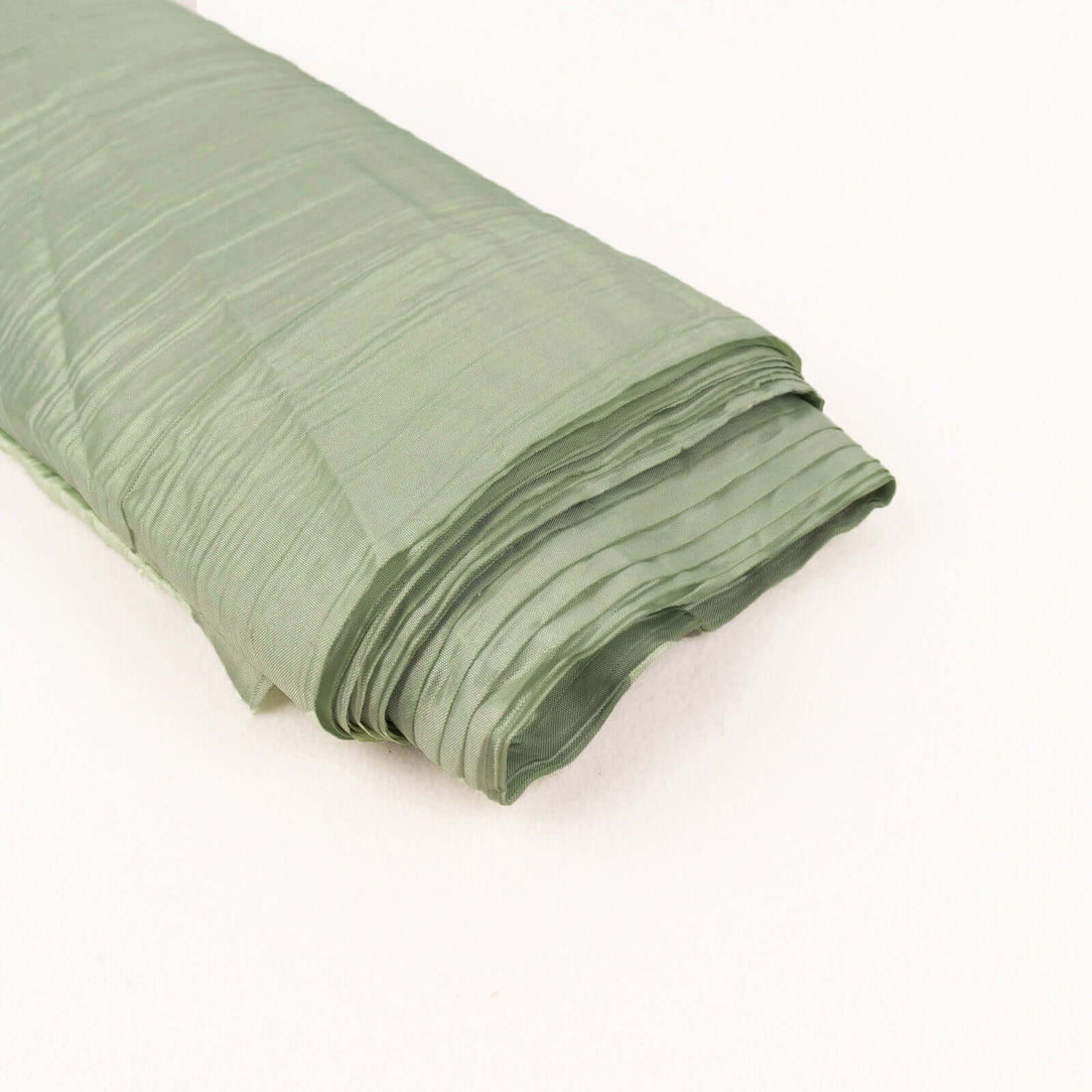 Green textured fabric roll on a light background.
