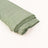 Green textured fabric roll on a light background.