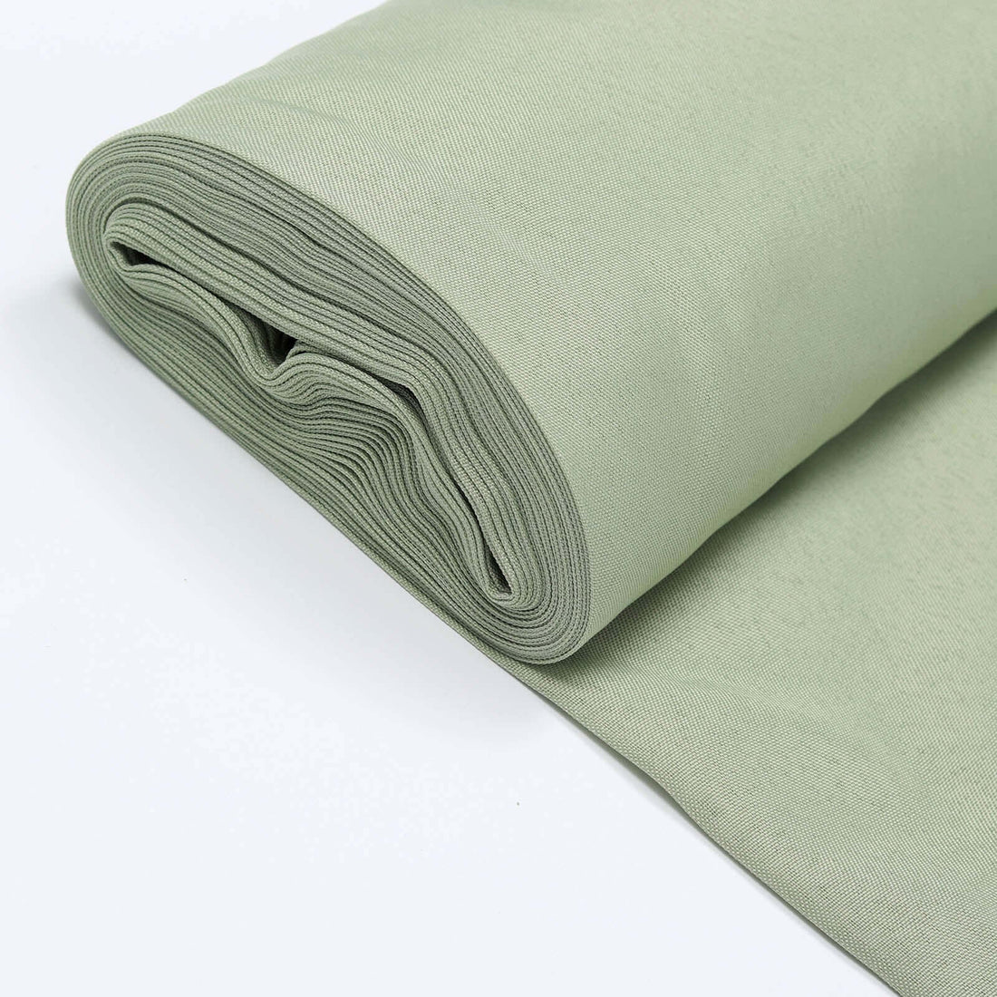 Rolled soft green fabric on a plain background