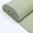 Rolled soft green fabric on a plain background