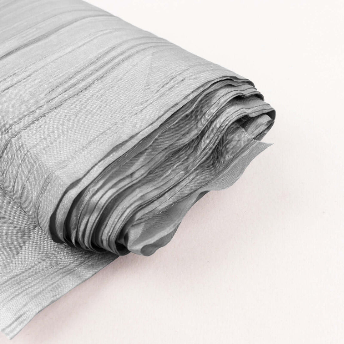 Wrinkled silver fabric roll on a soft background