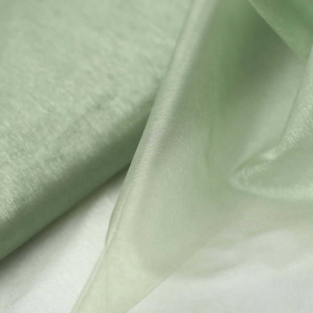 Light green fabric draped elegantly, showcasing its soft texture and sheen.