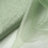 Light green fabric draped elegantly, showcasing its soft texture and sheen.