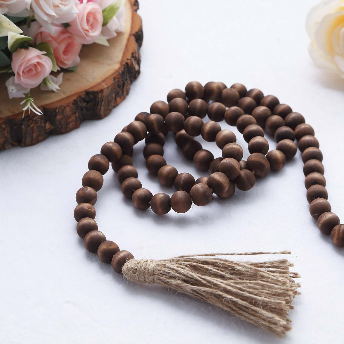 Wooden prayer beads with tassel on a white background.