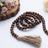 Wooden prayer beads with tassel on a white background.