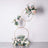 Floral arrangement with gold rings and pastel flowers on a white background