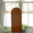 Brown fabric backdrop with arched frame and floral decorations.
